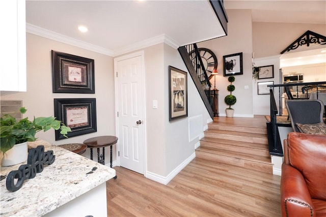 interior space featuring visible vents, baseboards, stairway, ornamental molding, and light wood-type flooring