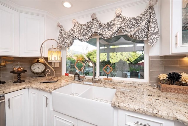 kitchen with white cabinets, decorative backsplash, and a sink