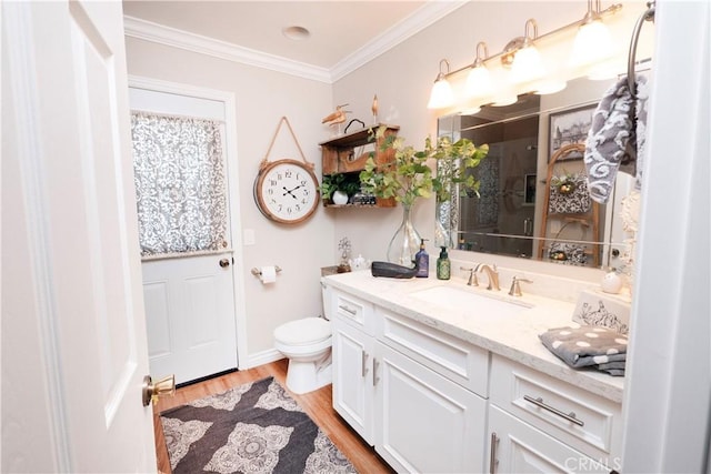 full bathroom featuring toilet, wood finished floors, vanity, baseboards, and ornamental molding