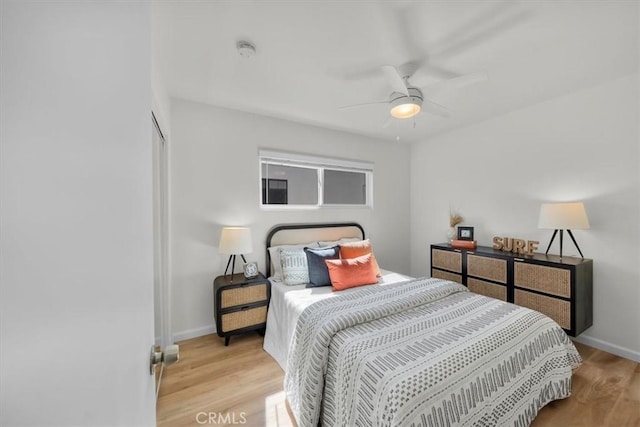 bedroom with light wood-style flooring, baseboards, and ceiling fan