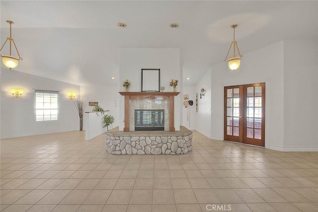 unfurnished living room featuring light tile patterned floors, a tile fireplace, baseboards, and french doors