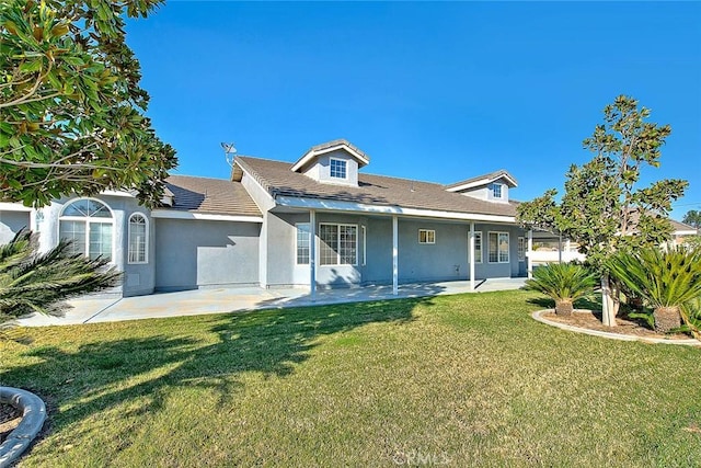 view of front facade featuring a patio, a front lawn, and stucco siding