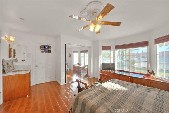 bedroom with a ceiling fan, baseboards, and light wood finished floors