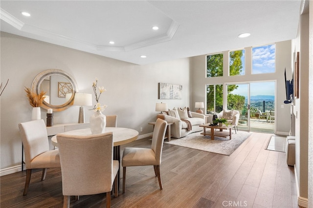 dining area featuring ornamental molding, a tray ceiling, and wood finished floors