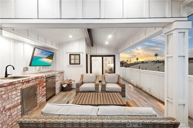 interior space with outdoor lounge area, a sink, and an outdoor kitchen