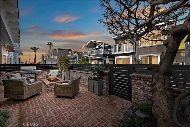 view of patio / terrace featuring a fire pit, grilling area, fence, and a balcony