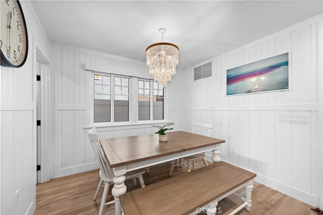 dining room featuring a chandelier, visible vents, and light wood-style flooring