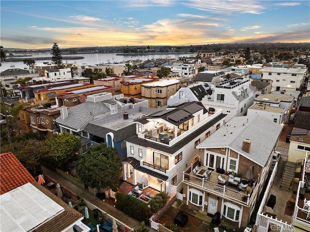 aerial view at dusk featuring a water view