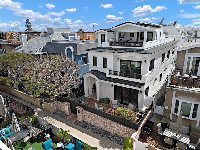 rear view of property featuring a residential view, a fenced backyard, and a balcony