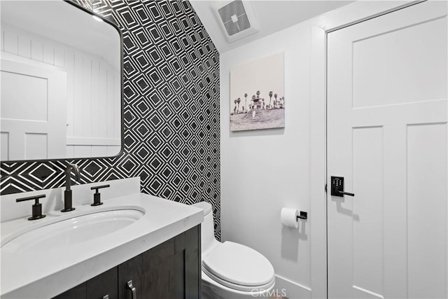 bathroom featuring visible vents, vanity, and toilet