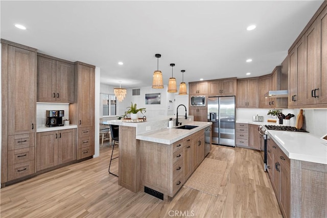 725 Dover Ct, San Diego, CA 92109 - kitchen featuring a sink, stainless steel appliances, light wood-type flooring, under cabinet range hood, and a kitchen bar