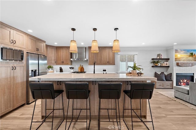 kitchen featuring light wood-type flooring, wall chimney range hood, a kitchen bar, and built in microwave