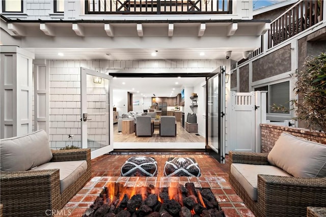 view of patio / terrace featuring outdoor dining space, a gate, a balcony, and an outdoor hangout area