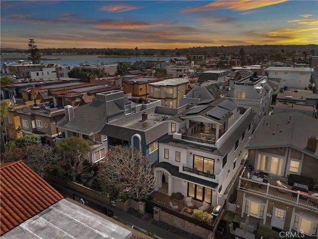 aerial view at dusk featuring a water view