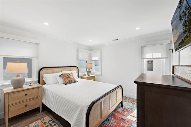 bedroom with ornamental molding, wood finished floors, visible vents, and recessed lighting