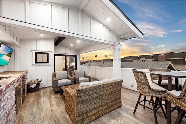 deck at dusk featuring an outdoor hangout area