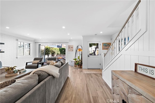 living area featuring recessed lighting, stairway, light wood-type flooring, and crown molding