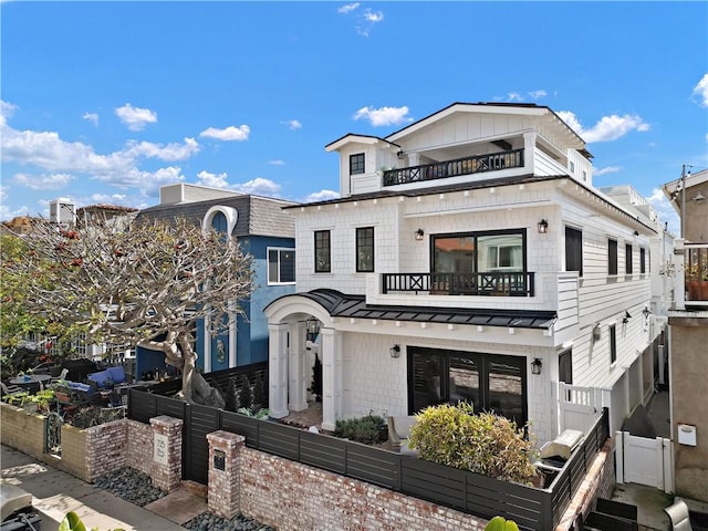 725 Dover Ct, San Diego, CA 92109 - view of front of home with a balcony, a standing seam roof, metal roof, a fenced front yard, and roof with shingles