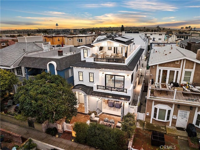 725 Dover Ct, San Diego, CA 92109 - back of house at dusk with a balcony, a shingled roof, outdoor lounge area, and a residential view