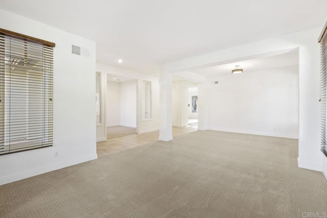 spare room with recessed lighting, visible vents, baseboards, and light colored carpet