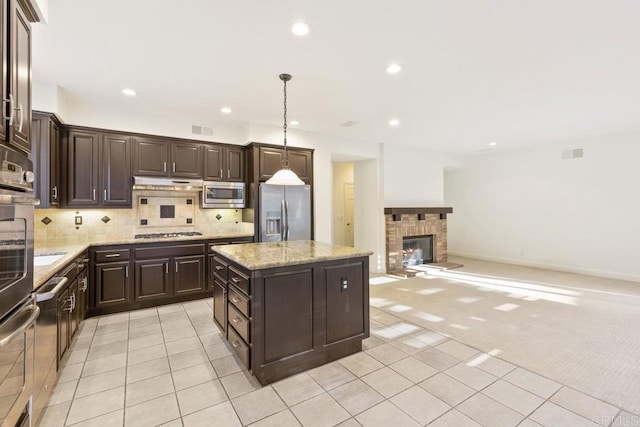 kitchen featuring dark brown cabinetry, stainless steel appliances, decorative backsplash, and light colored carpet