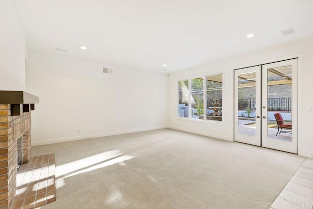 unfurnished living room featuring baseboards, french doors, a brick fireplace, and recessed lighting