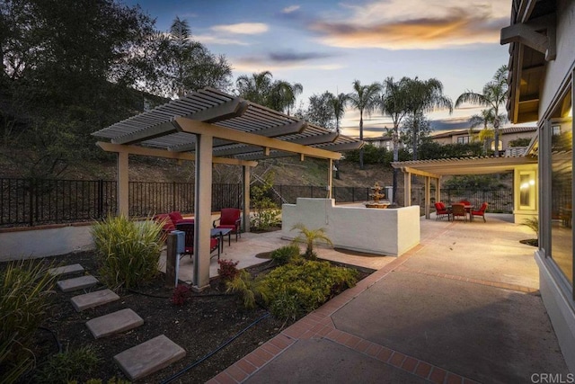 patio terrace at dusk with fence and a pergola