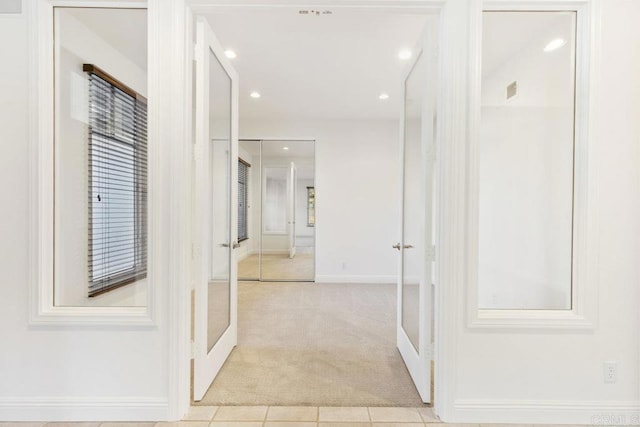 hall featuring recessed lighting, french doors, light colored carpet, and baseboards