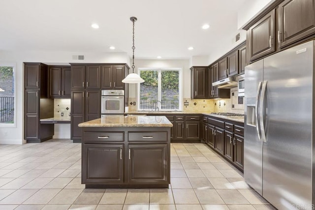 kitchen featuring light tile patterned flooring, dark brown cabinetry, under cabinet range hood, visible vents, and appliances with stainless steel finishes