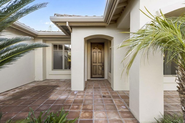 entrance to property with a patio and stucco siding