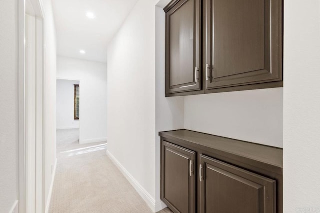 hallway featuring light carpet, baseboards, and recessed lighting