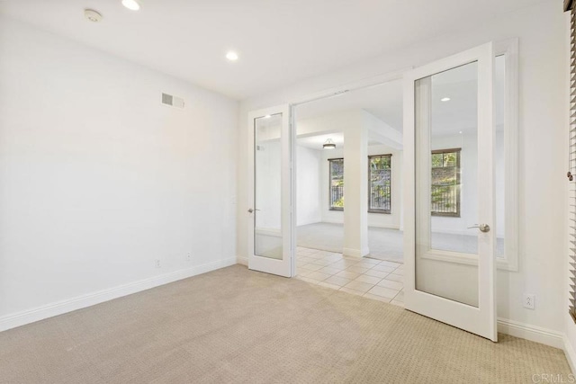 carpeted empty room featuring french doors, recessed lighting, visible vents, tile patterned flooring, and baseboards