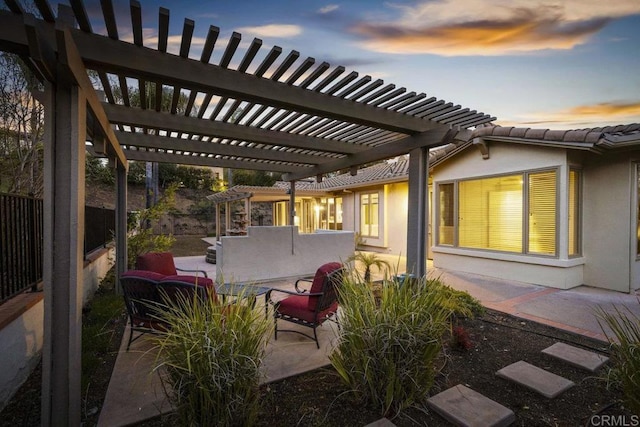 patio terrace at dusk with fence and a pergola