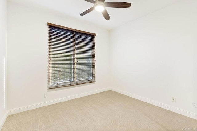 unfurnished room featuring ceiling fan, baseboards, and light colored carpet