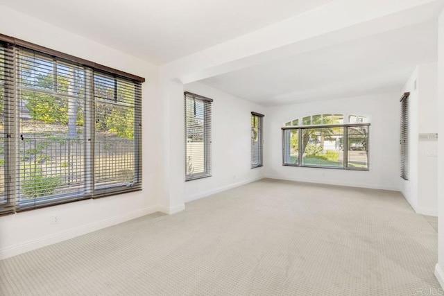 spare room with light carpet and baseboards