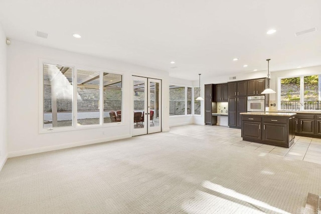 unfurnished living room featuring recessed lighting, visible vents, baseboards, and light colored carpet