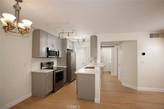 kitchen with light wood-style flooring, gray cabinetry, visible vents, light countertops, and appliances with stainless steel finishes