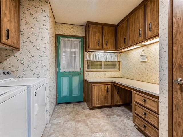 washroom with cabinet space, a textured ceiling, separate washer and dryer, and wallpapered walls