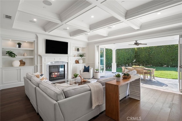 living room featuring dark wood finished floors, visible vents, a high end fireplace, coffered ceiling, and beamed ceiling