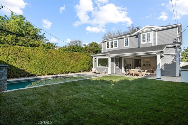 rear view of house featuring a fenced in pool, a lawn, fence, and a patio