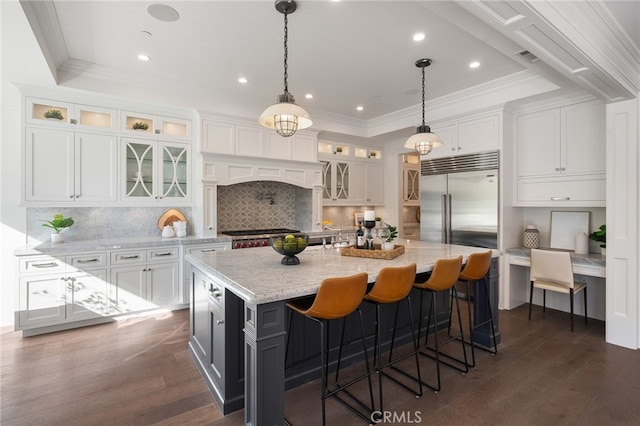 kitchen with dark wood-style floors, white cabinetry, a tray ceiling, and stainless steel appliances