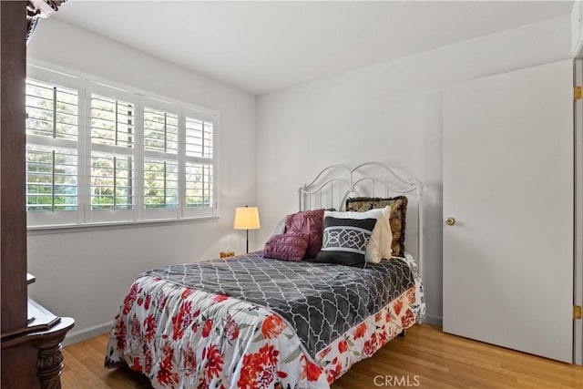 bedroom featuring baseboards and wood finished floors