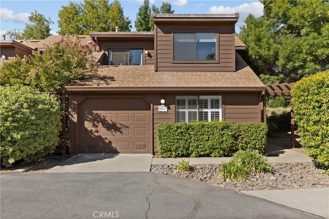 view of front of property featuring roof with shingles, driveway, and an attached garage