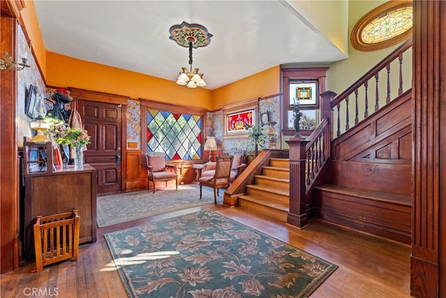 entryway with stairs, a chandelier, and hardwood / wood-style flooring