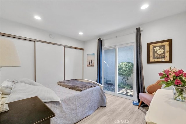 bedroom with access to exterior, light wood finished floors, a closet, and recessed lighting