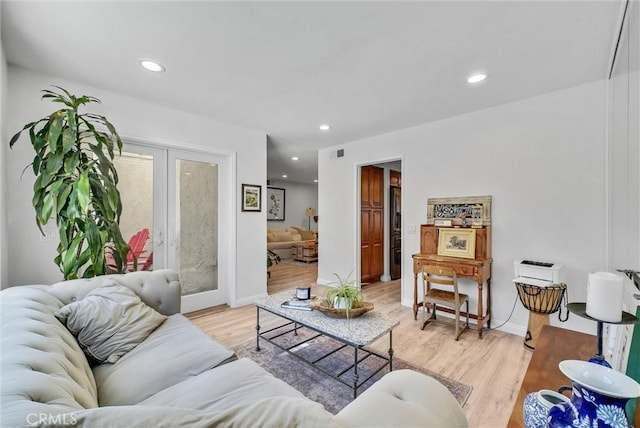 living room featuring baseboards, french doors, recessed lighting, and light wood-style floors