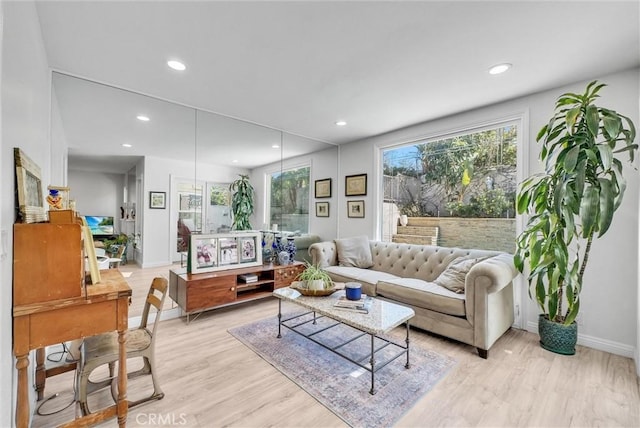 living area with a healthy amount of sunlight, light wood-style floors, baseboards, and recessed lighting