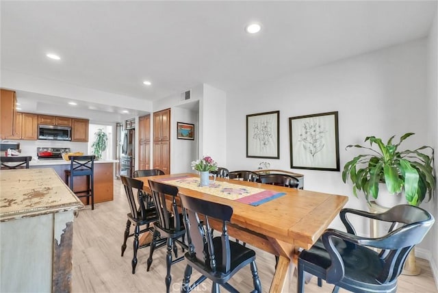 dining area with light wood-style floors, visible vents, and recessed lighting