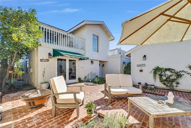 back of house featuring french doors, outdoor lounge area, a patio, and stucco siding