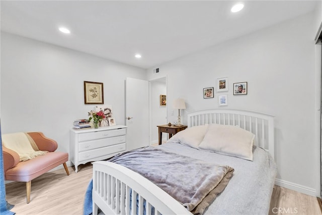 bedroom with baseboards, light wood-style flooring, visible vents, and recessed lighting